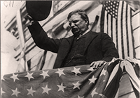 Theodore Roosevelt tips his hat to the crowd on the campaign trail