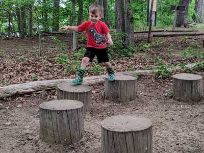 Boy jumping between tree sections