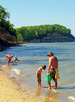 Family fossil hunting on beach in Calvert Cliffs State Park